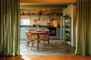 Eine Küche mit Esstisch, Stühlen und einem grünen Schrank.