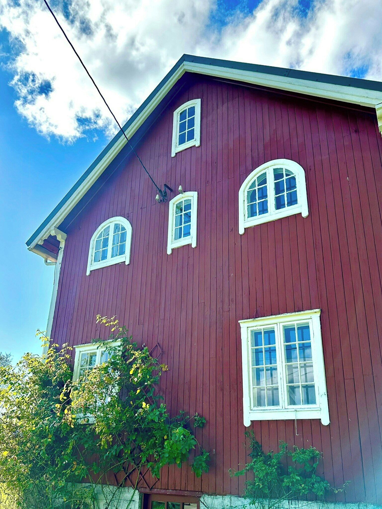 A red building with multiple windows and a visible power line.