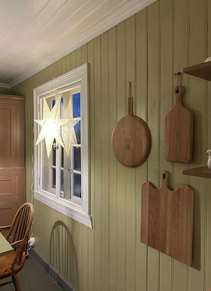 A room with a window, a star-shaped light fixture, and wooden wall decorations. - Charming farmhouse from 1919 near Kristiansund (Kristiansund)