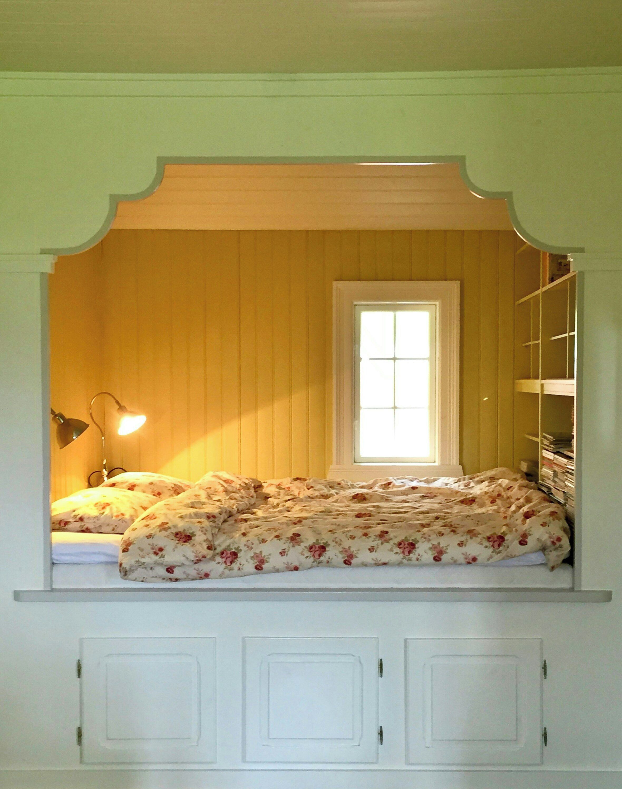 Een kamer met een bed, een raam en een plank met boeken.
