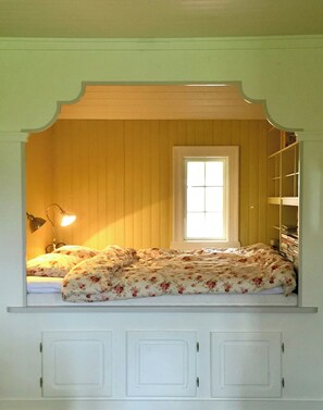 A room with a bed, a window, and a shelf with books. - Charming farmhouse from 1919 near Kristiansund (Kristiansund)