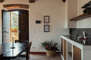 Eine Küche mit einem Holztisch, einem Blumenkorb und einer Kaffeemaschine.