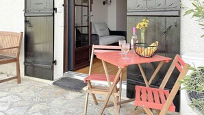 An outdoor seating area with a table and chairs, a bench, and a potted plant. - Apartment in villa with shared pool in Razac (Razac-sur-l'Isle)