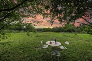 Ein Sitzbereich im Freien mit Tisch, Stühlen und einer Flasche.