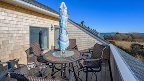 Une terrasse avec une table et des chaises, un parasol et une vue sur le paysage.