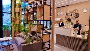 A modern interior with a reception desk, wooden shelving, and decorative clocks. - Yot Hotel Algiers (Algiers)