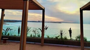 A covered outdoor area with a view of a body of water and distant cityscape. - Yot Hotel Algiers (Algiers)