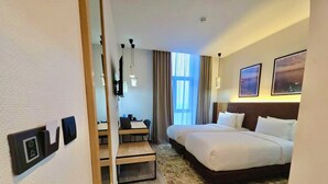 A hotel room with a bed, desk, chair, and a view of the outdoors. - Yot Hotel Algiers (Algiers)