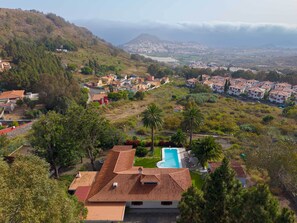 A residential area with houses, a swimming pool, and a hilly landscape in the background. - Exclusive Villa Mirador de Arucas - Family & Friends (Arucas)