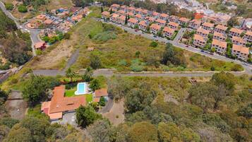Vista aérea de uma área residencial com vários edifícios de apartamentos, uma piscina e vegetação ao redor.