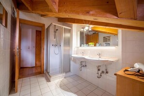 A bathroom with a shower, sink, and mirror. - Vrbo Property (Zell am See)
