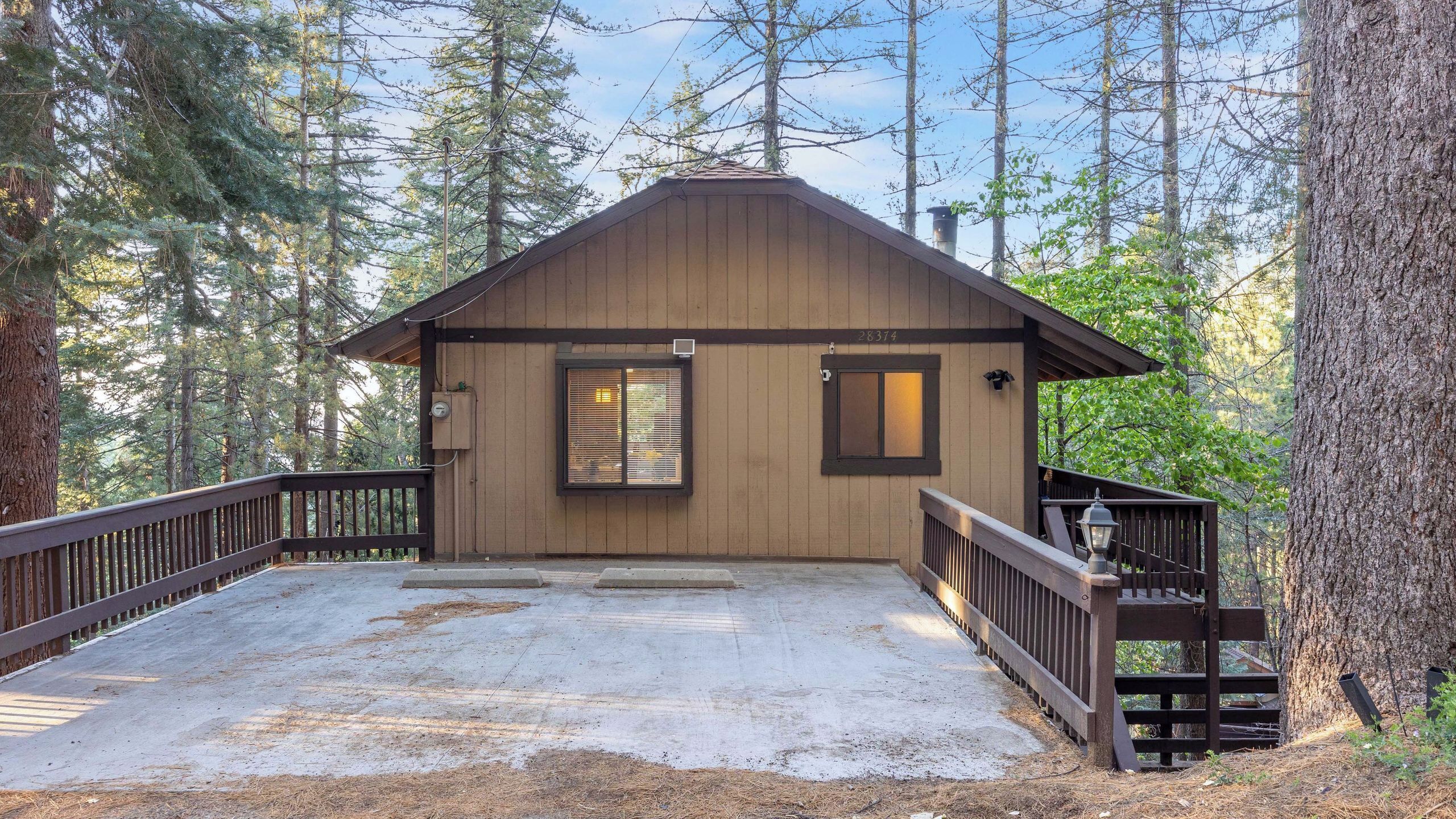 A cabin with a wooden exterior, a front porch, and a small deck.