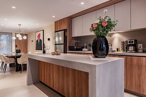 Eine moderne Küche mit Kochinsel, Holzschränken und einer Vase mit Blumen.