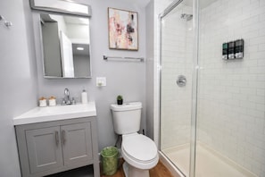 A modern bathroom with a shower, toilet, and vanity. - Chicago Edgewater 3BR - 9 Min Walk to Loyola (Chicago)