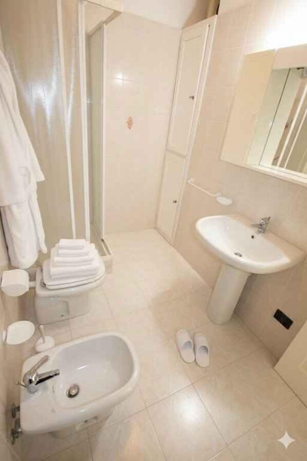Une salle de bain équipée d’un lavabo, d’un bidet et d’une douche.