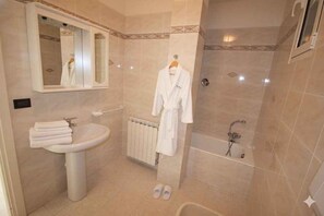 A bathroom with a sink, mirror, robe rack, and bathtub. - Holiday apartment with garden and sea view (Poggi Inferiore Poggi Superiore)