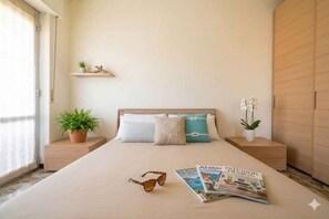 Ein Schlafzimmer mit einem Bett, Nachttischen, einem Regal mit Pflanzen und einer Zeitschrift auf dem Bett.