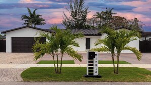A modern house with a garage, a driveway, and a mailbox with the number 12813.