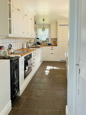 A kitchen with white cabinets, a stove, and a sink.