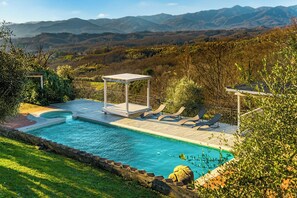 A swimming pool with a deck, lounge chairs, and a gazebo. - Panoramic villa with pool in Lunigiana (Fivizzano)