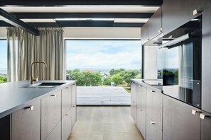 Eine moderne Küche mit Blick ins Freie, integrierten Geräten und einem eleganten Design.