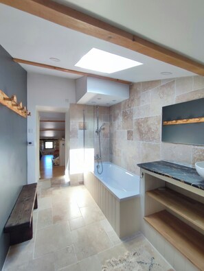 A modern bathroom with a bathtub, shower, and a skylight. - Renovated silk farm in Joyeuse (Joyeuse)