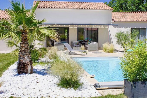 A modern house with a swimming pool, outdoor seating, and a palm tree. - Contemporary villa in Aix-en-Provence vineyards (Le Puy-Sainte-Réparade)