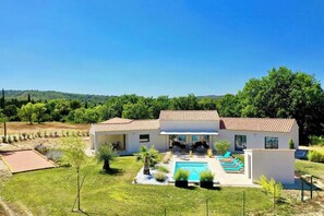 A two-story house with a swimming pool, a patio with lounge chairs, and a garden. - Contemporary villa in Aix-en-Provence vineyards (Le Puy-Sainte-Réparade)
