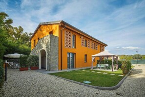 A modern building with a stone facade, a covered patio, and a well-maintained lawn. - Beautiful apartment near Lucca with pool (Capannori)
