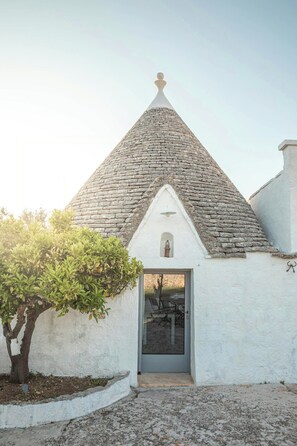 A small building with a stone roof and a white exterior. - Traditional Puglian trullo (Ostuni)