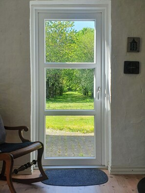 A double door with a view of a green park. - Converted factory from 1950 with its own forest (Hadsund)