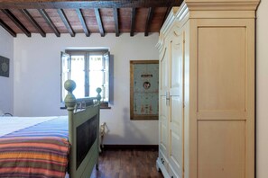Una camera da letto con un letto, una finestra, un armadio e una parete con un quadro incorniciato.