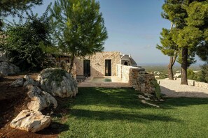 A stone building with a patio and a view of the sea. - Trullo with salt pool and sea view near Ostuni (Ostuni)