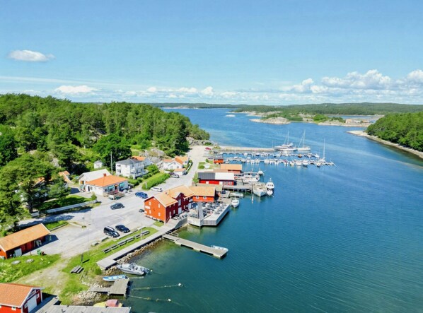 En kuststad med en småbåtshamn, hus och en fri utsikt över vattnet.