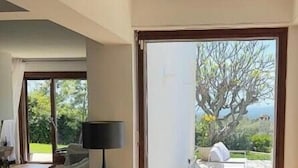 Ein modernes Interieur mit einer großen Schiebeglastür, die auf eine Terrasse im Freien führt.