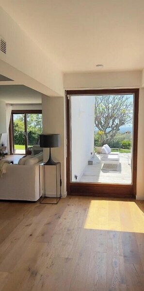 A modern interior with a large sliding glass door leading to an outdoor patio. - Villa with panoramic views of the French Riviera (La Gaude)
