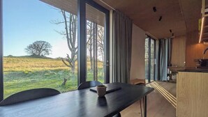 A modern kitchen with a view of a grassy field and trees. - Tiny house overlooking nature (Vordingborg)