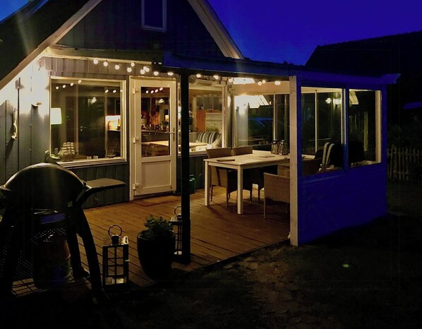 A covered outdoor area with a table and chairs, a potted plant, and a grill. - Sleep under the stars near Brunsnæs Beach (Broager)