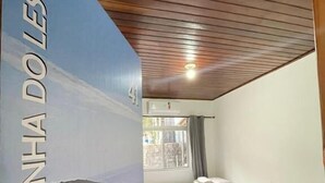 Une chambre d’hôtel avec un lit, une petite table et une fresque murale.