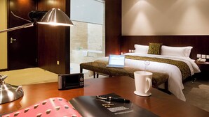 A hotel room with a bed, bedside table, lamp, laptop, and a coffee cup. - Beijing Wanshang Garden Hotel (Beijing)