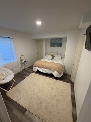 A bedroom with a bed, a bedside table, a lamp, a window with blinds, and a painting on the wall. - 14 minutes to Denver airport, hot tub, sleeps 4, near Gaylord Rockies (Commerce City)