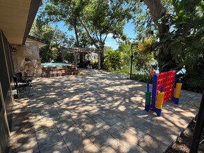 Eine Terrasse mit Kiesbecken, Sitzgelegenheiten im Freien und einer Kinderspielanlage.