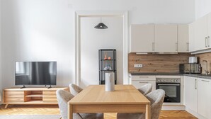 Een moderne keuken met witte kasten, een houten aanrecht, een inbouwoven en een magnetron.