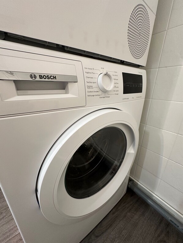 A Bosch washing machine with a control panel, a front-loading door, and a vent on top.