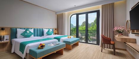 Habitación de hotel con cama, dos mesitas de noche, una silla, televisión y balcón con vistas.
