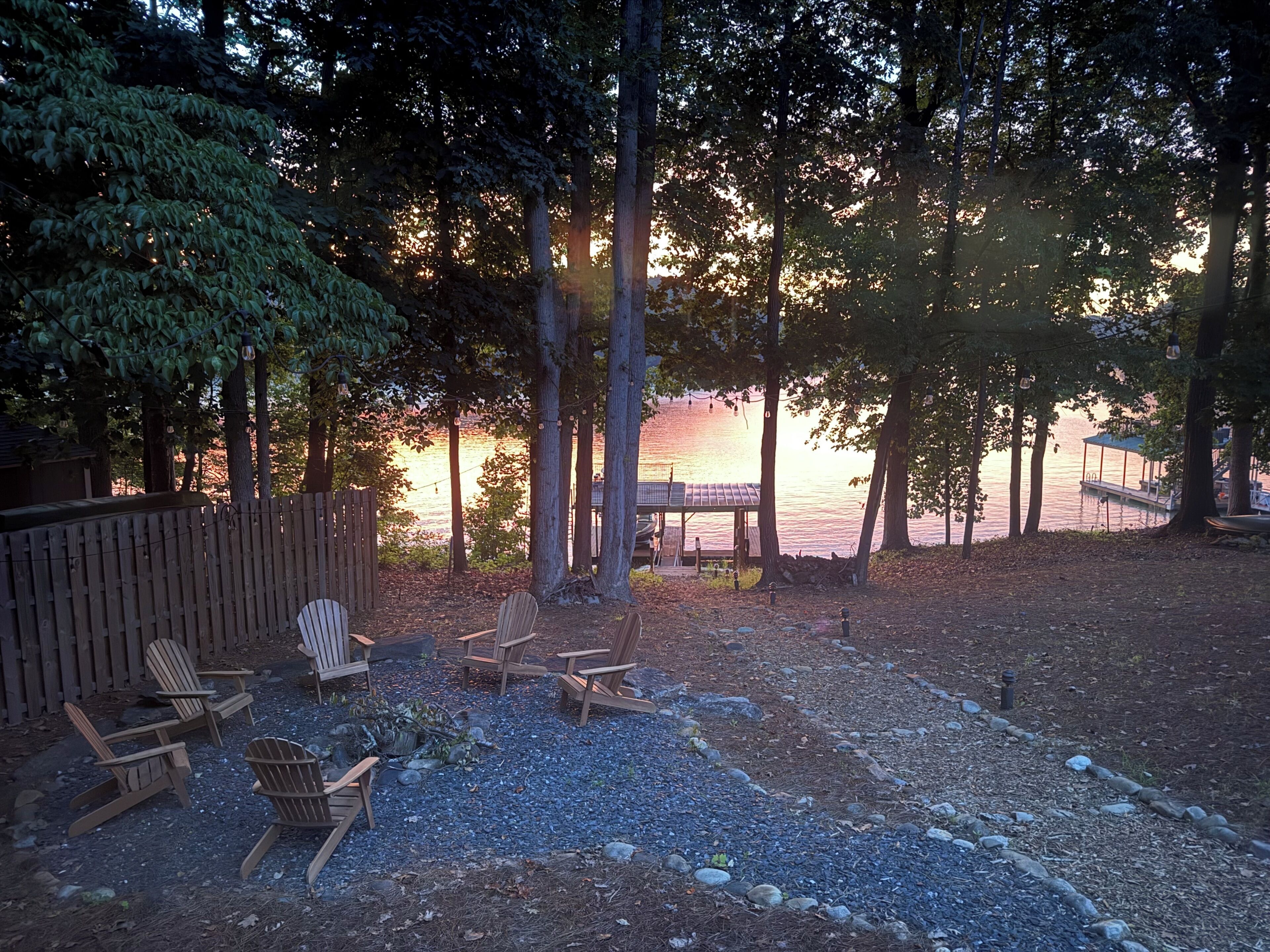 Une terrasse au bord du lac, avec des chaises en bois et un belvédère.
