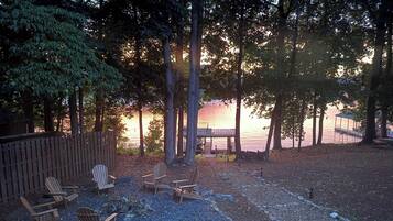Une terrasse au bord du lac, avec des chaises en bois et un belvédère.