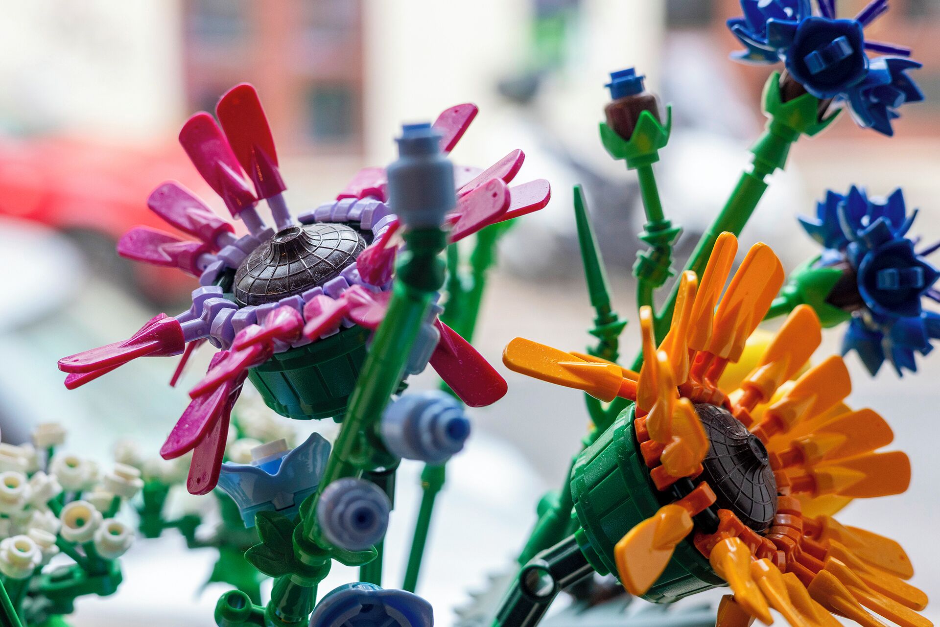 Close-up van kleurrijke speelgoedbloemen, met een bij op een van de bloemen.