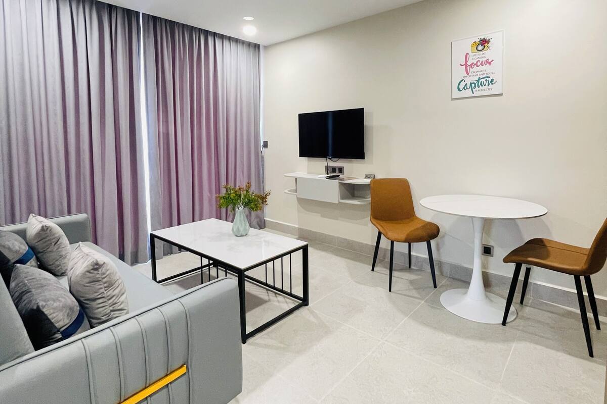 Una sala de estar moderna con un sofá, una mesa de centro y un comedor con sillas y una mesa.