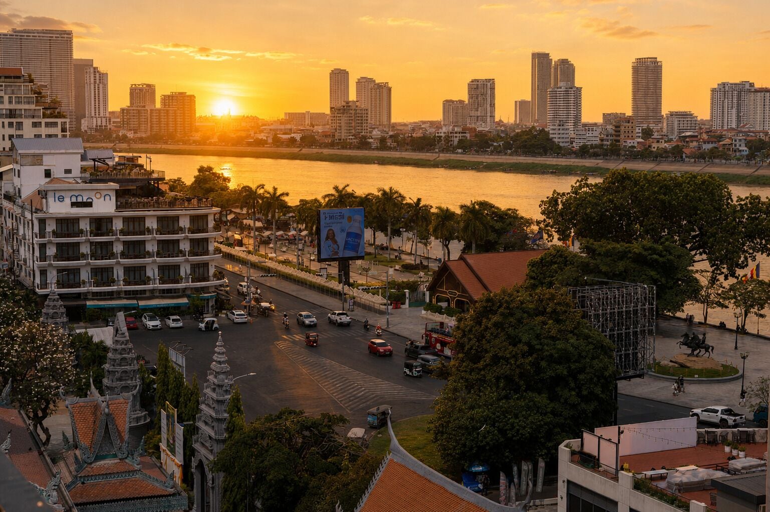 Un paisaje urbano con un río, edificios y un atardecer.